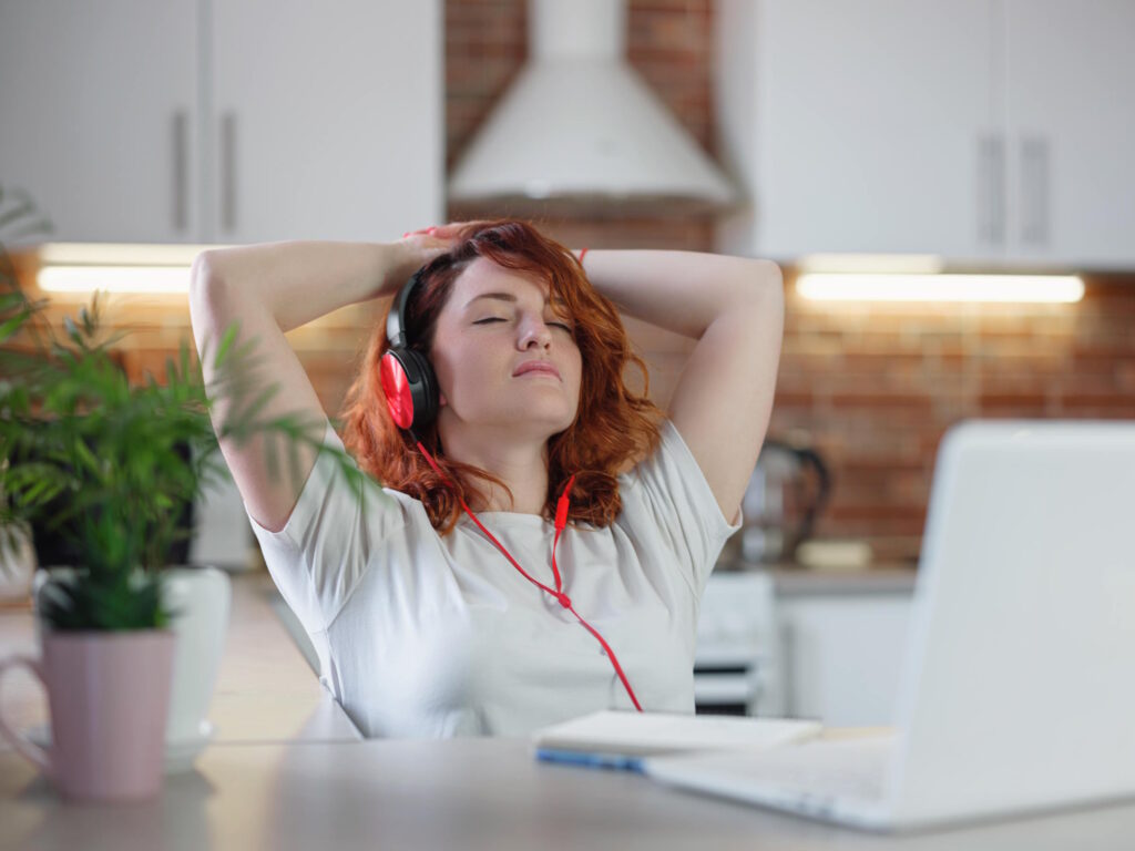 A woman with headphones appears to be serene, potentially experiencing the calm before a gripping plot twist in a suspenseful audio story.