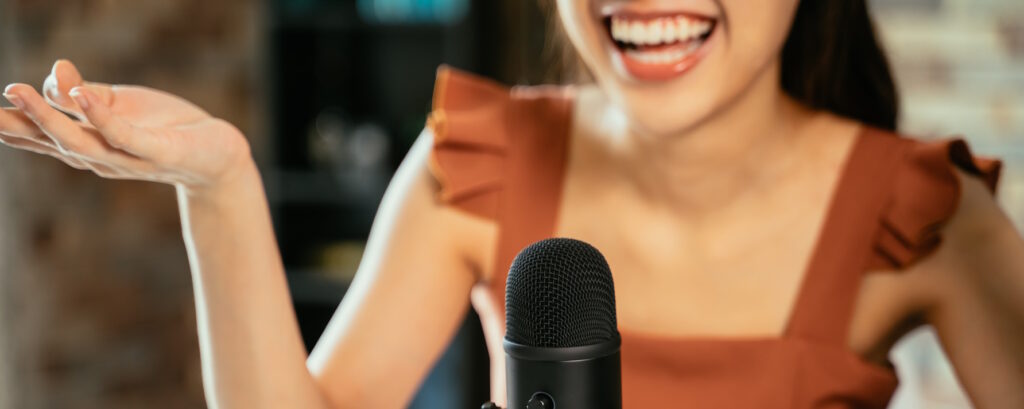 Podcaster in a striped sweater laughing joyfully while recording a podcast, embodying the essence of podcast audience engagement.